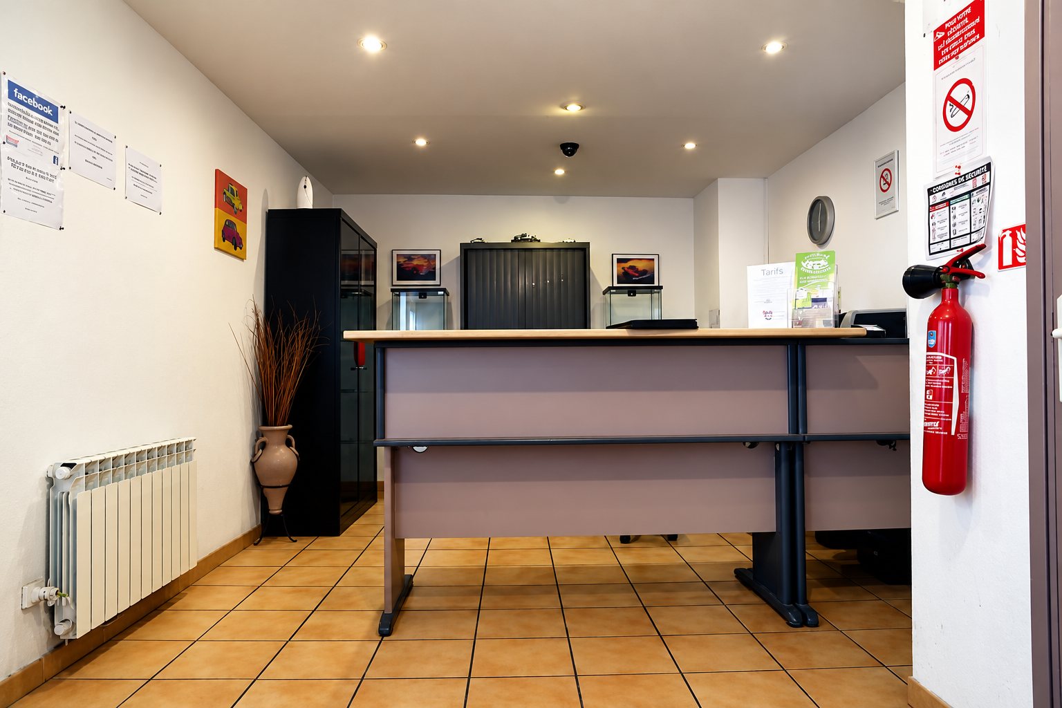 Accueil du centre : comptoir, extincteur et carrelage orangé