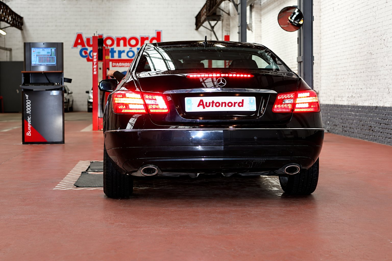 Coupé Mercedes noir vu de l'arrière sur la piste de contrôle